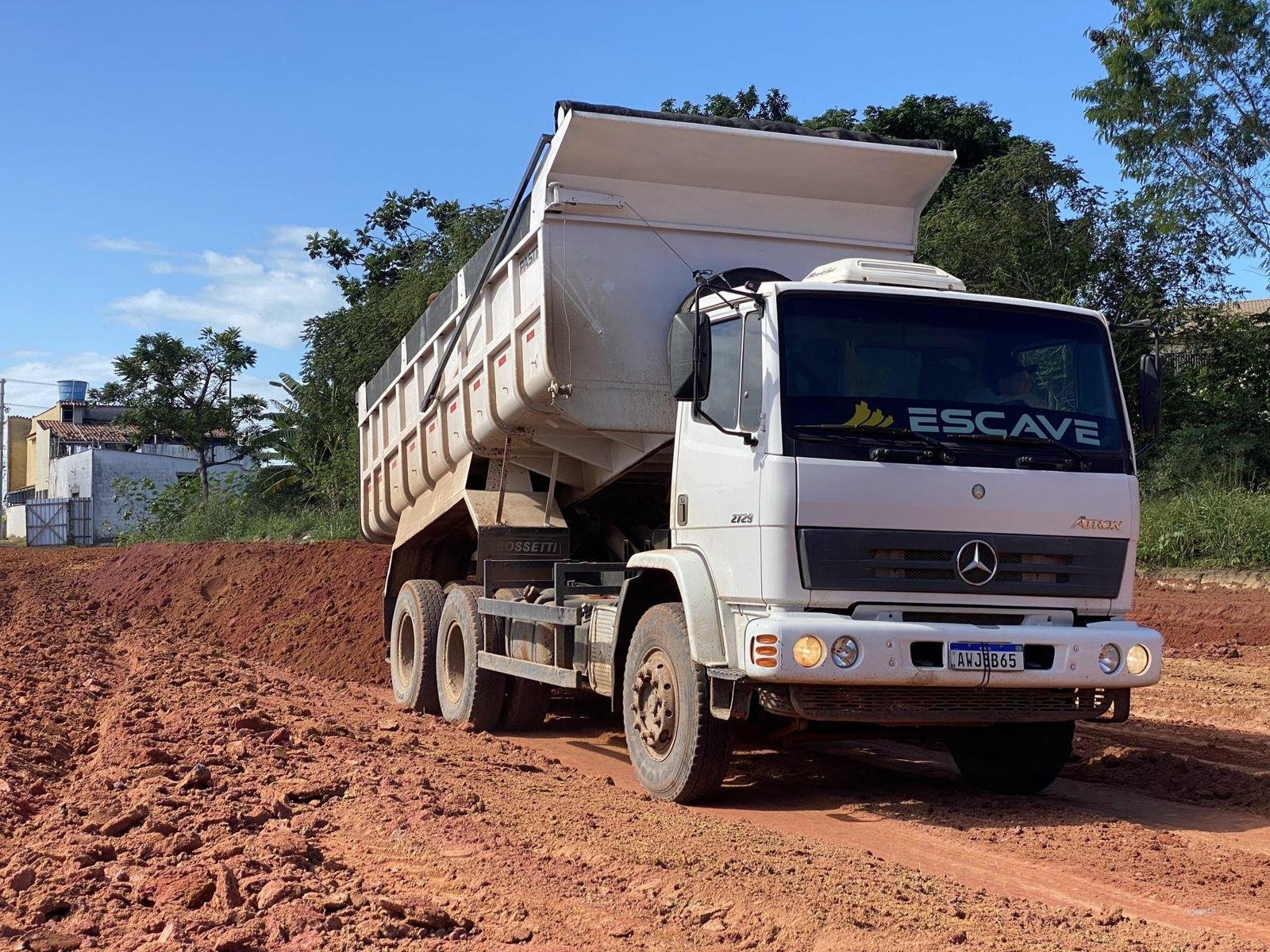 Caminhão basculante Escave descarregando em canteiro de terraplenagem