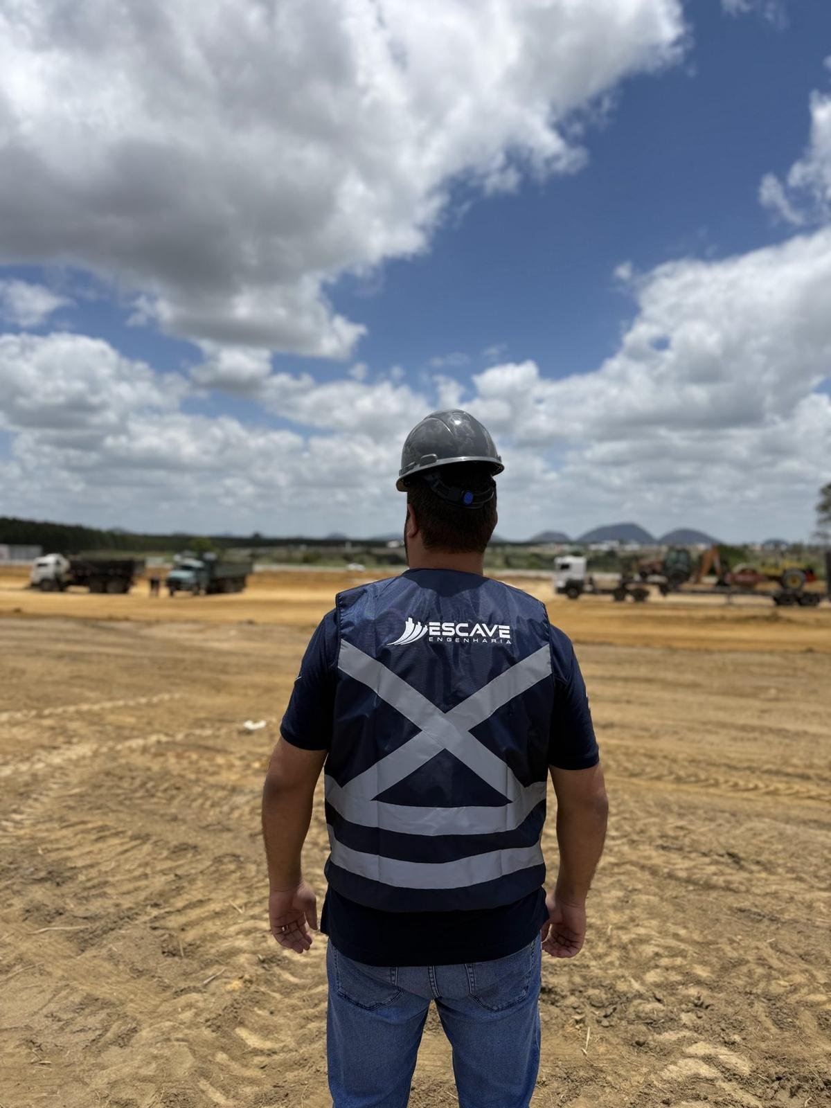 Colaborador da Escave com colete refletivo observando a frente de terraplenagem